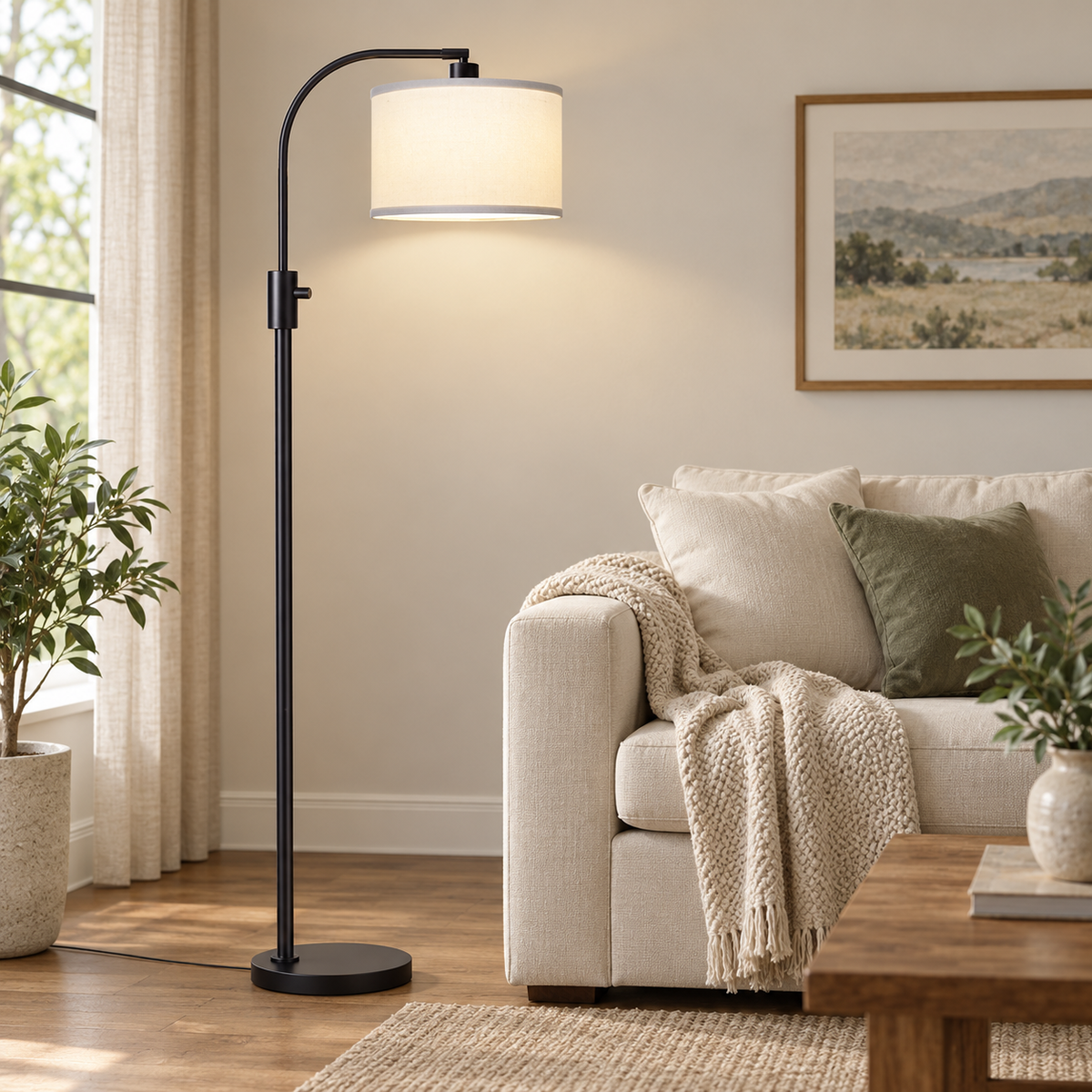 Matte black arc floor lamp with a white shade standing next to a cream sofa.