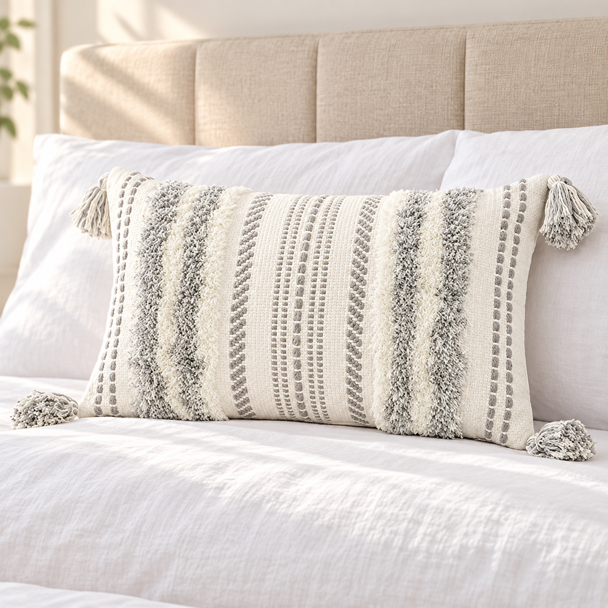Grey and cream white 20x12 lumbar tufted pillow cover on a white bed with beige headboard.