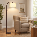 Matte brown arc floor lamp with a beige linen shade next to a taupe armchair.