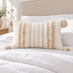 Khaki and cream white 20x12 lumbar tufted pillow cover on a white bed against a beige headboard.
