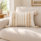 Khaki and cream white 20x12 lumbar tufted pillow cover with corner tassels on an oatmeal sofa.