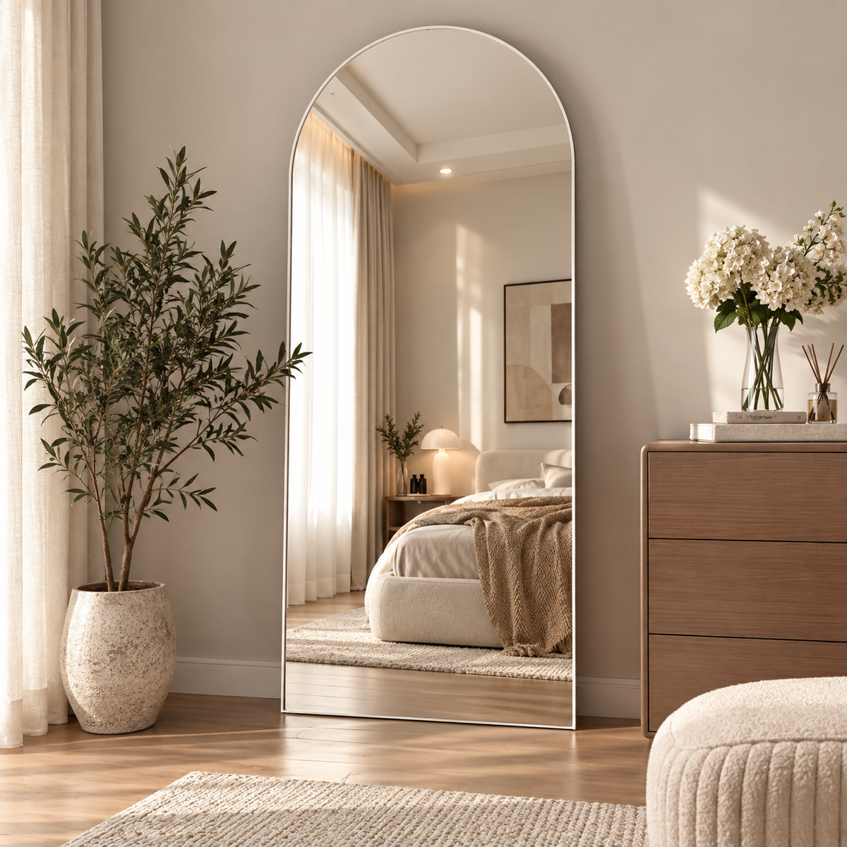 A cozy modern bedroom interior featuring an oversized arched full length floor mirror by HavvakHome.
