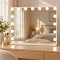 White rectangular vanity mirror with 15 lighted bulbs set on a light-oak bedroom vanity table.