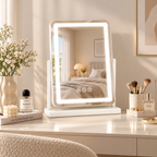 White rectangular tabletop vanity mirror with LED border and three touch icons on a white dressing table reflecting a bedroom, brushes, and flowers beside it by HavvakHome.