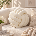 HavvakHome soft cream knot ball pillow resting on a textured beige sofa in a bright living room.