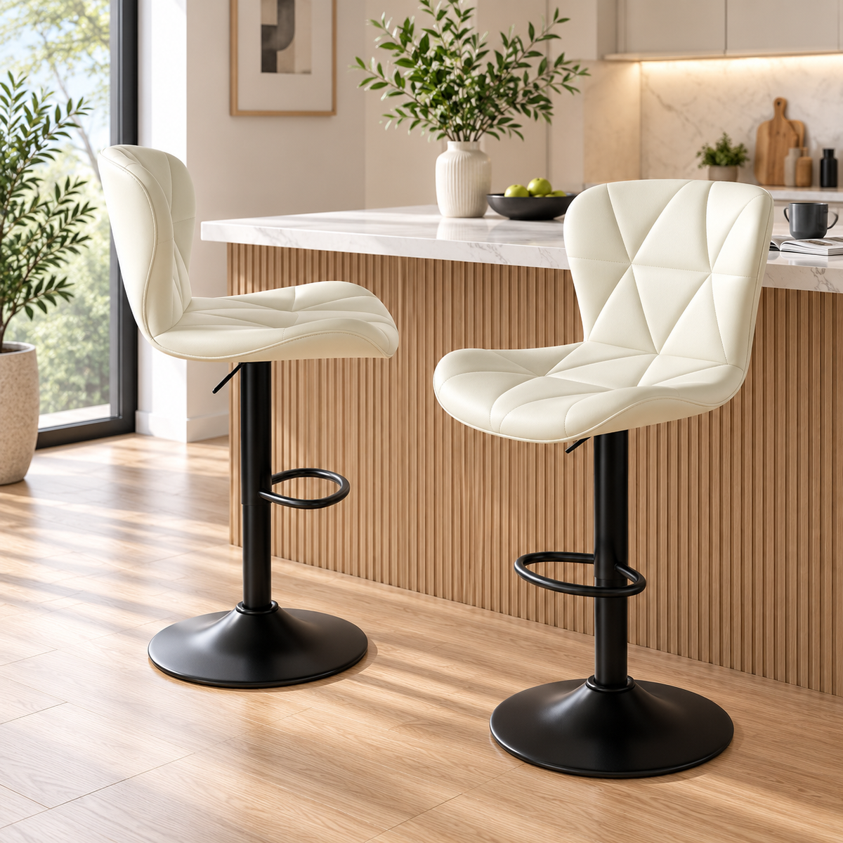 Two cream white quilted bar stools with black pedestal bases and footrests shown from side and front three-quarter angles beside a kitchen island by HavvakHome.