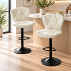 Two cream white quilted bar stools with black pedestal bases and footrests styled beside a wood slatted kitchen island by HavvakHome.