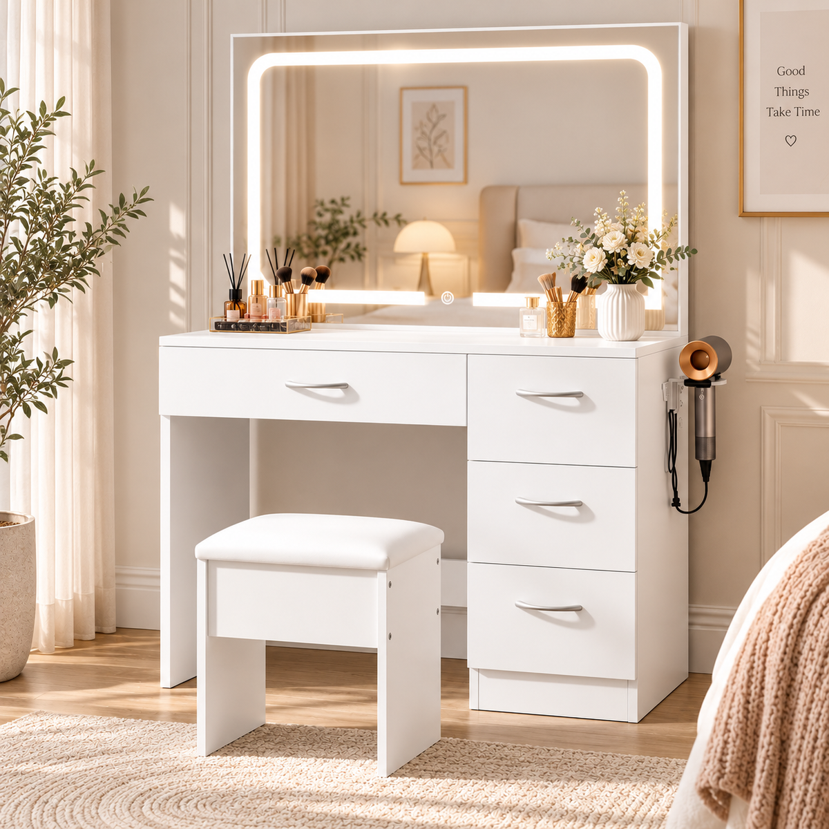 HavvakHome white vanity desk and matching padded stool beside a window featuring a warm illuminated rectangular mirror, cosmetics, a flower vase, and a bed reflected in the mirror.