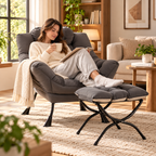Woman reading a book and holding a mug in a gray lounge chair with feet on a matching ottoman and cream throw in a sunny living room by HavvakHome.