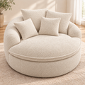 Cream round boucle cuddle chair with four matching square throw pillows and a round seat in a bright room by HavvakHome.