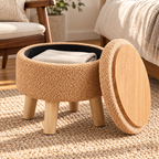 Champagne round storage ottoman with lid leaning aside revealing wood-grain tray back and black interior storage.