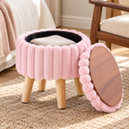 Light pink plush faux fur ottoman with lid removed leaning to show wood-grain underside and black storage interior.