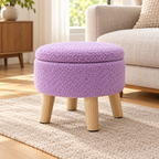 Purple nubby fleece round storage ottoman with four light wood legs and closed lid on a light oak floor.