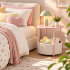 Pink round bedside table with a cream basket holding books and a flower cushion, featuring a green lamp, clock, and flowers on the tabletop beside a bed by HavvakHome.