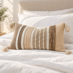 Brown 20x12 inch lumbar pillow cover featuring vertical woven details and tassels arranged on a white bed.