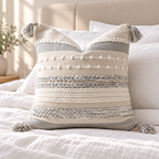 Gray and white 18x18 inch square throw pillow cover with horizontal textured details arranged on a white bed.