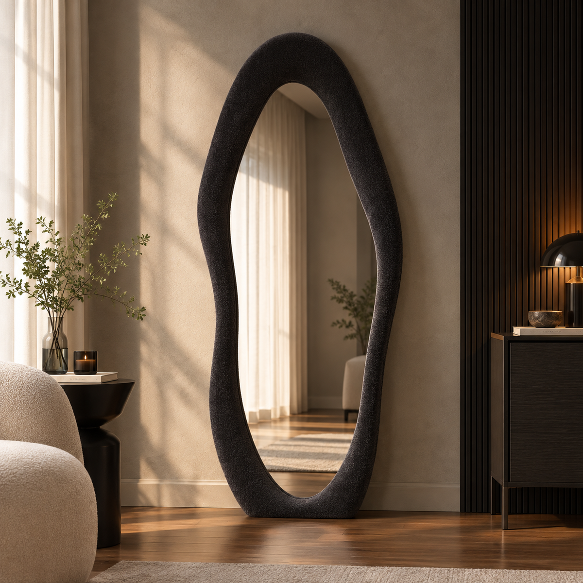Black wavy flannel-framed floor mirror leaning beside a wood-slat wall, reflecting window curtains.
